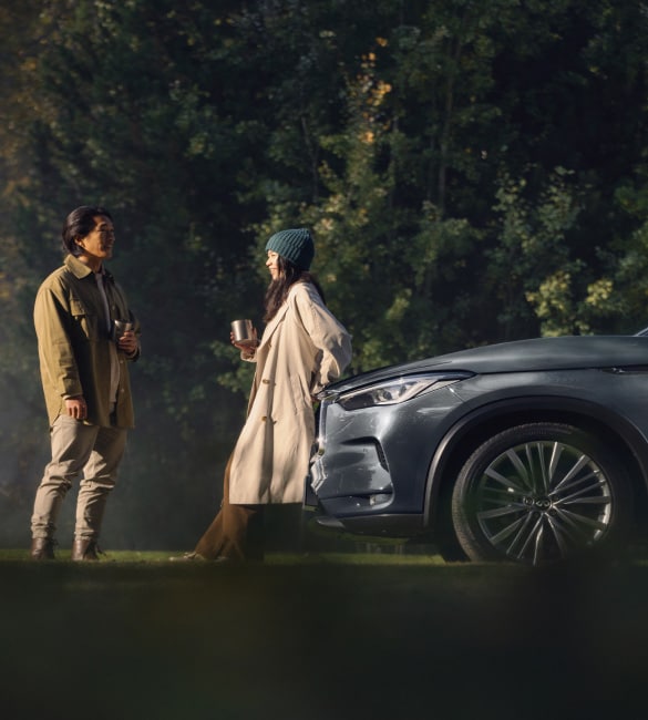 Couple talking in front of their INFINITI QX50 luxury Crossover SUV